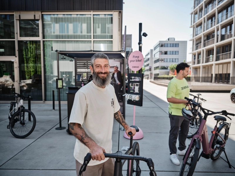 Mann schiebt Gravel und lächelt in die Kamera Mann schiebt Gravel und lächelt in die Kamera